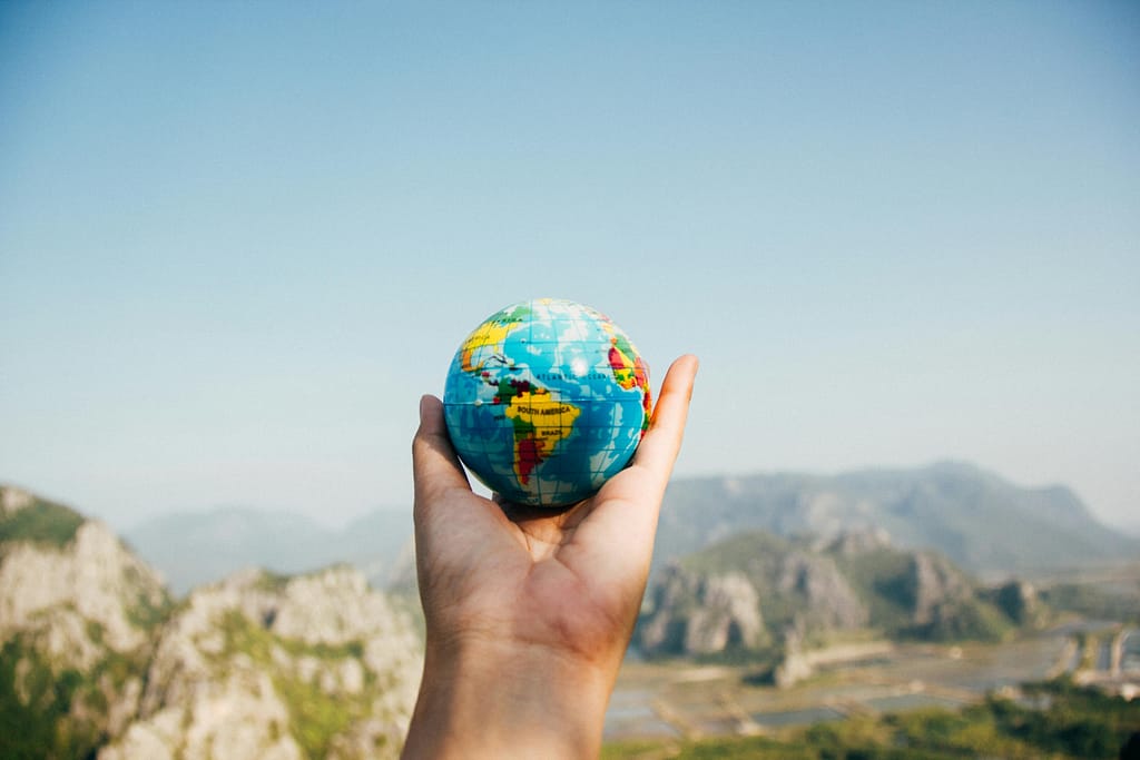 Free stock photo of a hand holding a small globe