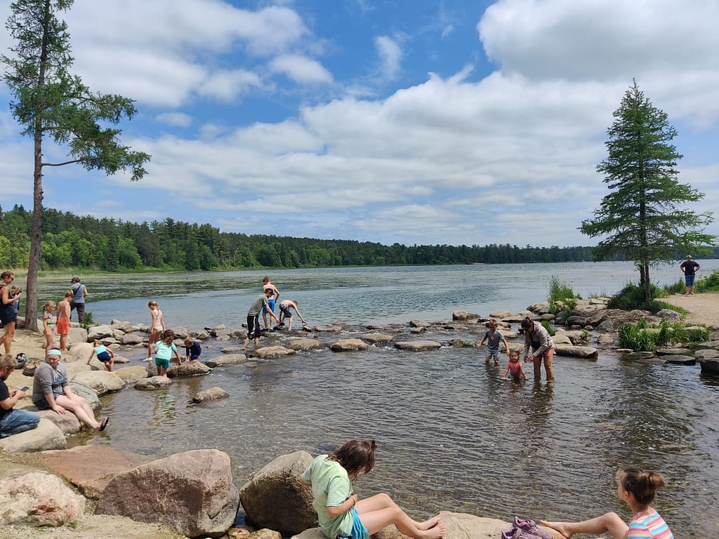 People playing and swimming in the Mississippi River on the Mississippi Headwaters Trail at Itasca State Park in Park Rapids, MN