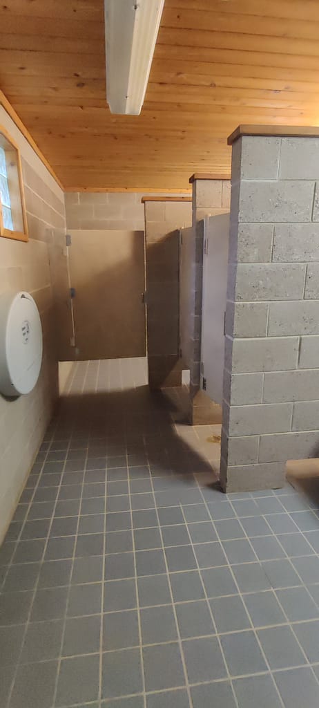 Bathroom in the campground. There's an accessible stall at the end. 