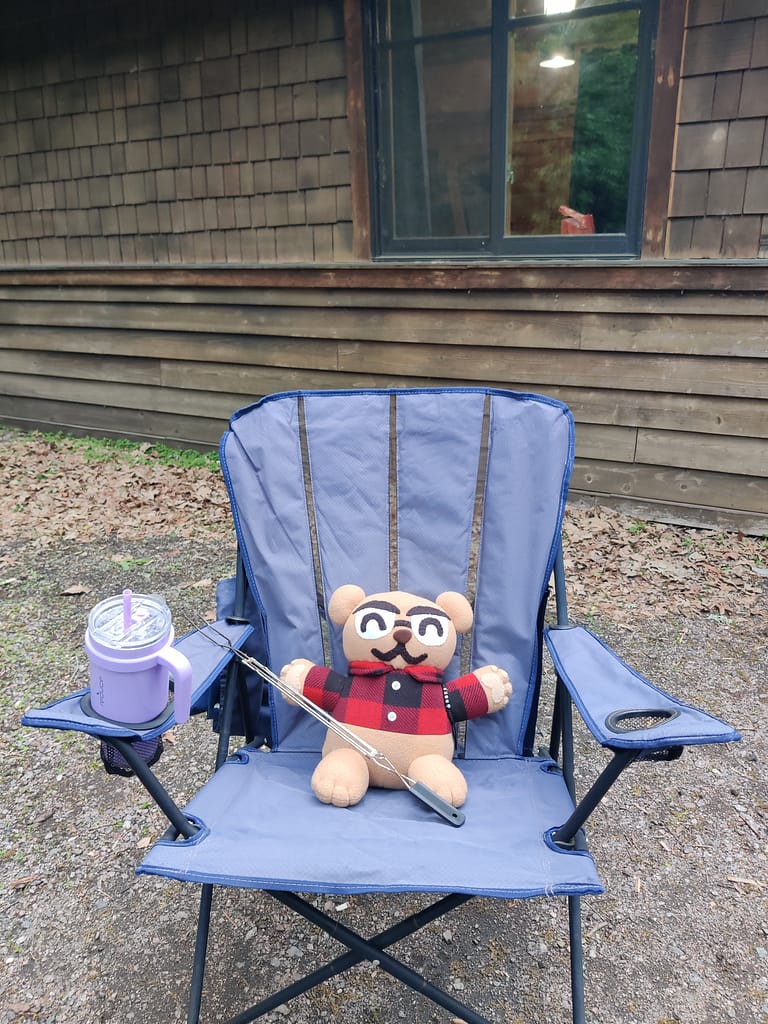 Cardybear sitting on a chair outside of the cabin at Glacial Lakes State Park in Starbuck, MN