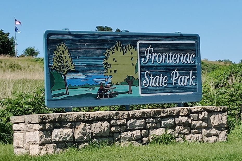 Blue sign with white writing that reads Frontenac State Park in Frontenac, MN