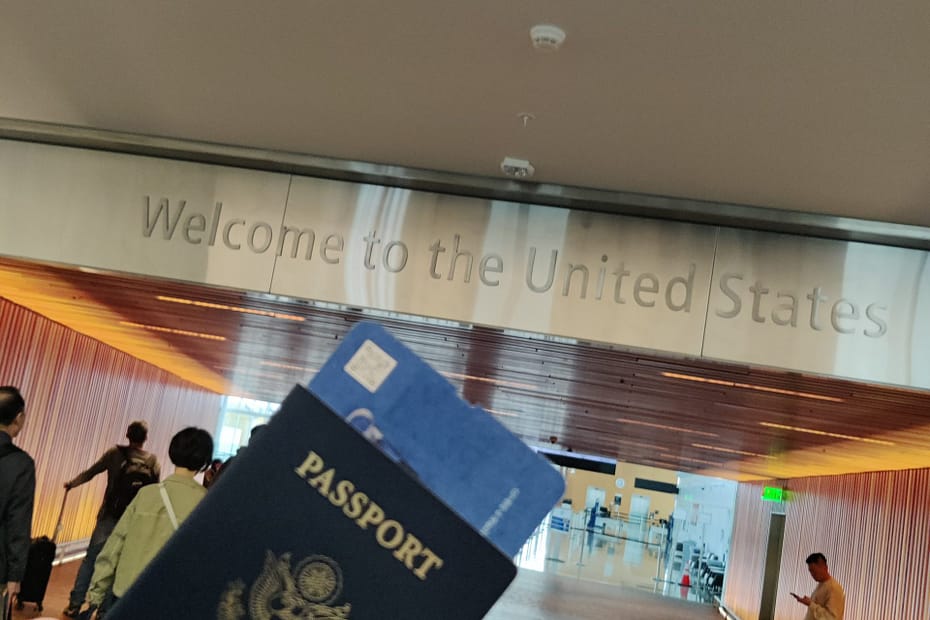 Seleana's passport by the Welcome sign at Seattle airport in Seattle, Washington