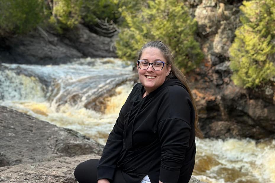 Seleana sitting on a rock at Cascade State Park in MInnesota