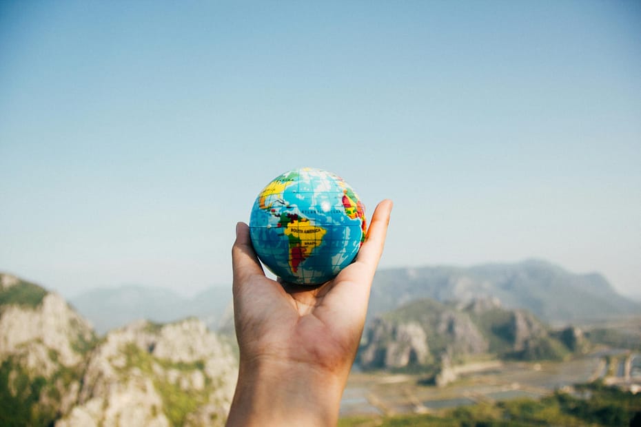 Free stock photo of a hand holding a small globe